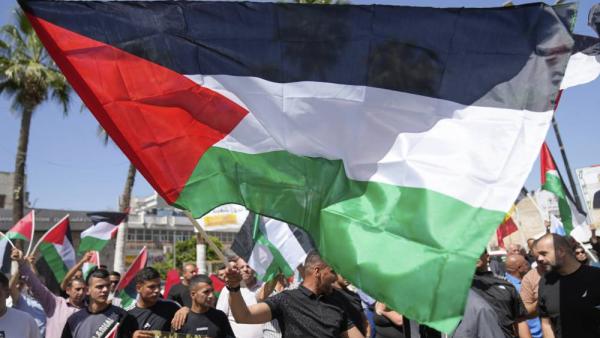 فلسطينيون يرفعون أعلامهم خلال تظاهرة دعماً لغزة واحتفالاً بأحدث اعترافات الدول الغربية بالدولة الفلسطينية في رام الله (أ ب )