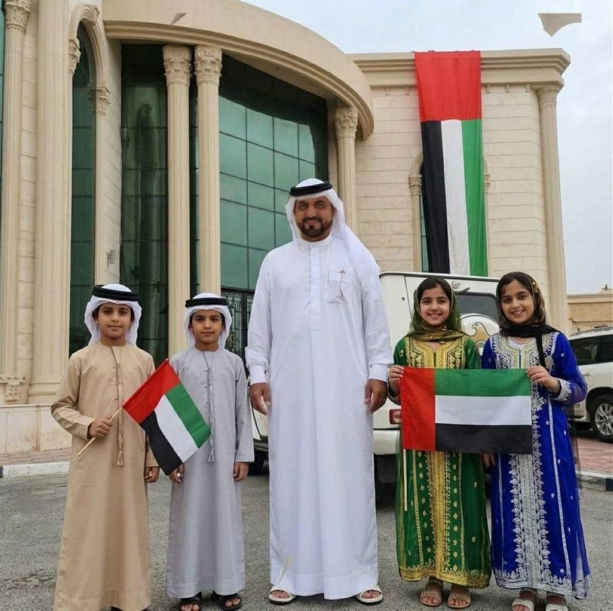 فيصل الحمادي برفقة أبنائه حاملين العلم