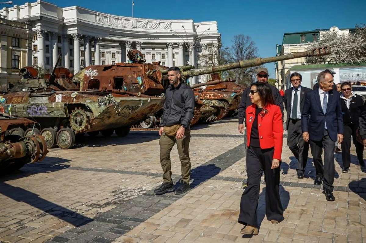 وزيرة الدفاع الإسبانية مارغريتا روبلز تسير بالقرب من معدات عسكرية روسية مدمرة معروضة  في كييف (رويترز)