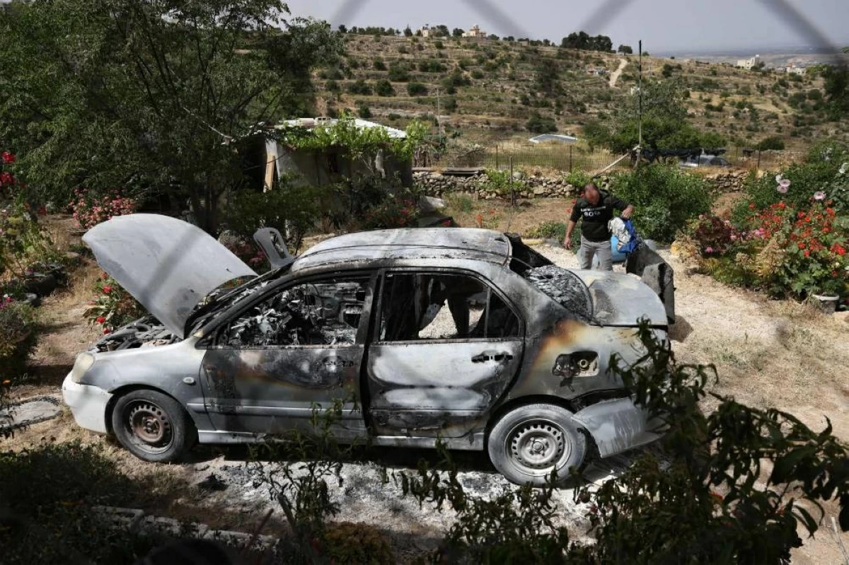 سيارة فلسطينية أحرقها مستوطنون في قرية صوريف، قرب مدينة الخليل (ا ف ب)