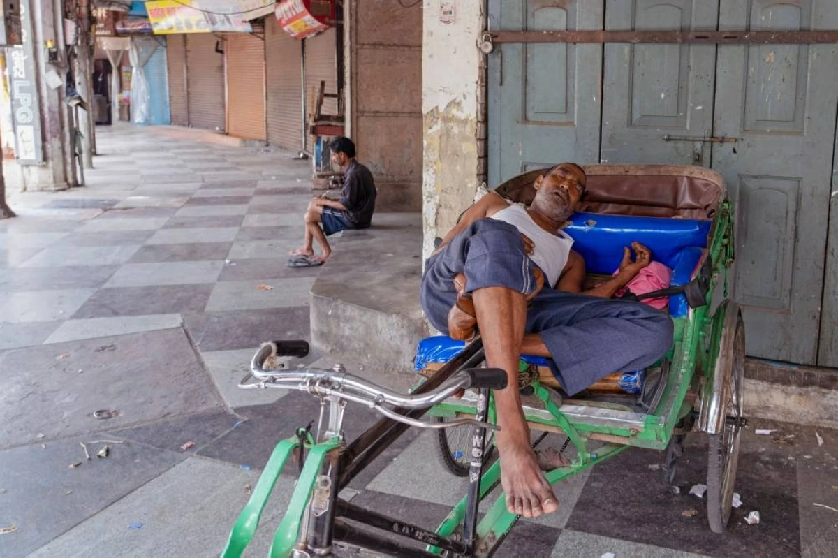 سائق 'ركشة' يستريح من أثر موجة الحر (أ.ب)