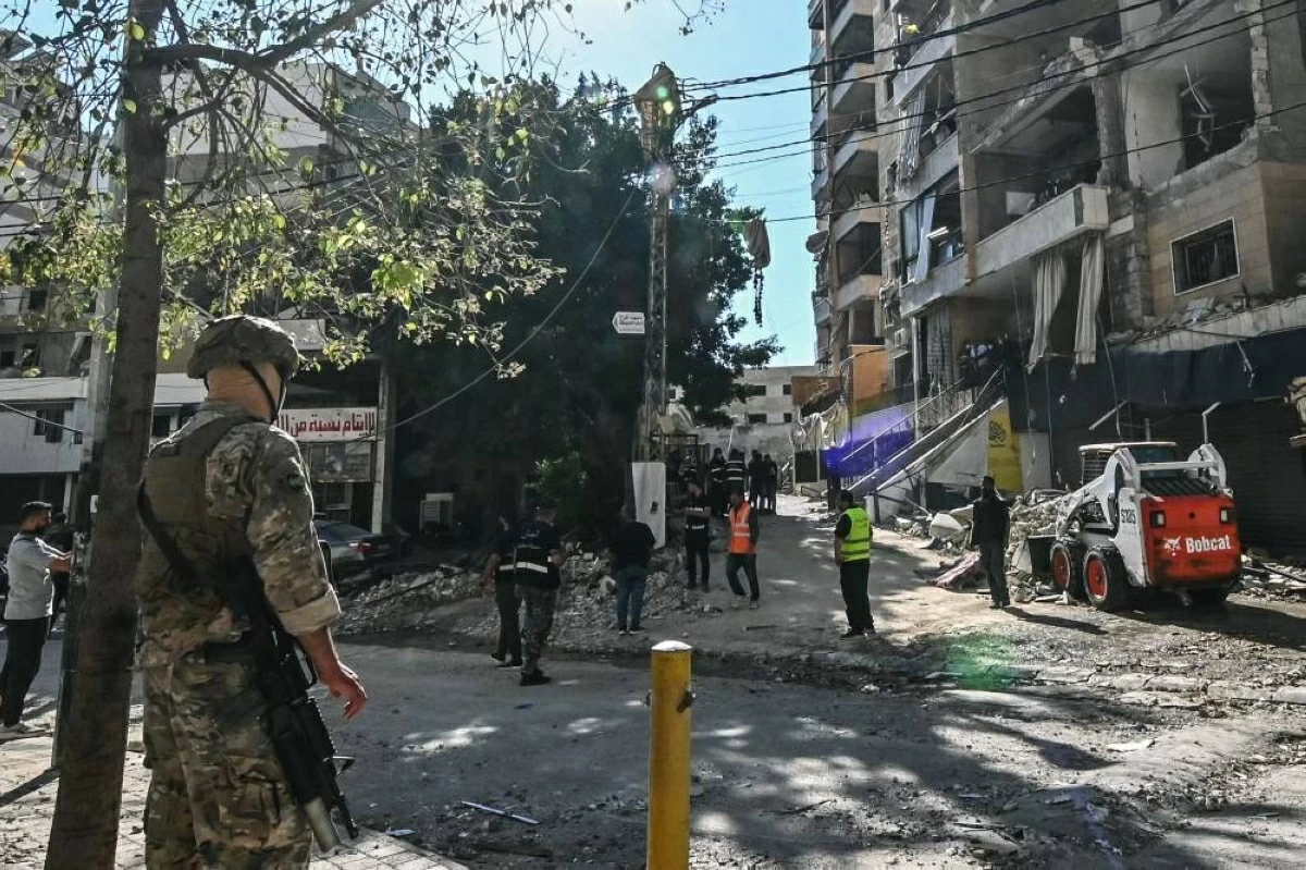  جندي لبناني يقف حارساً أمام مبنى استهدفته غارة إسرائيلية في ضاحية بيروت الجنوبية (أ ف ب)