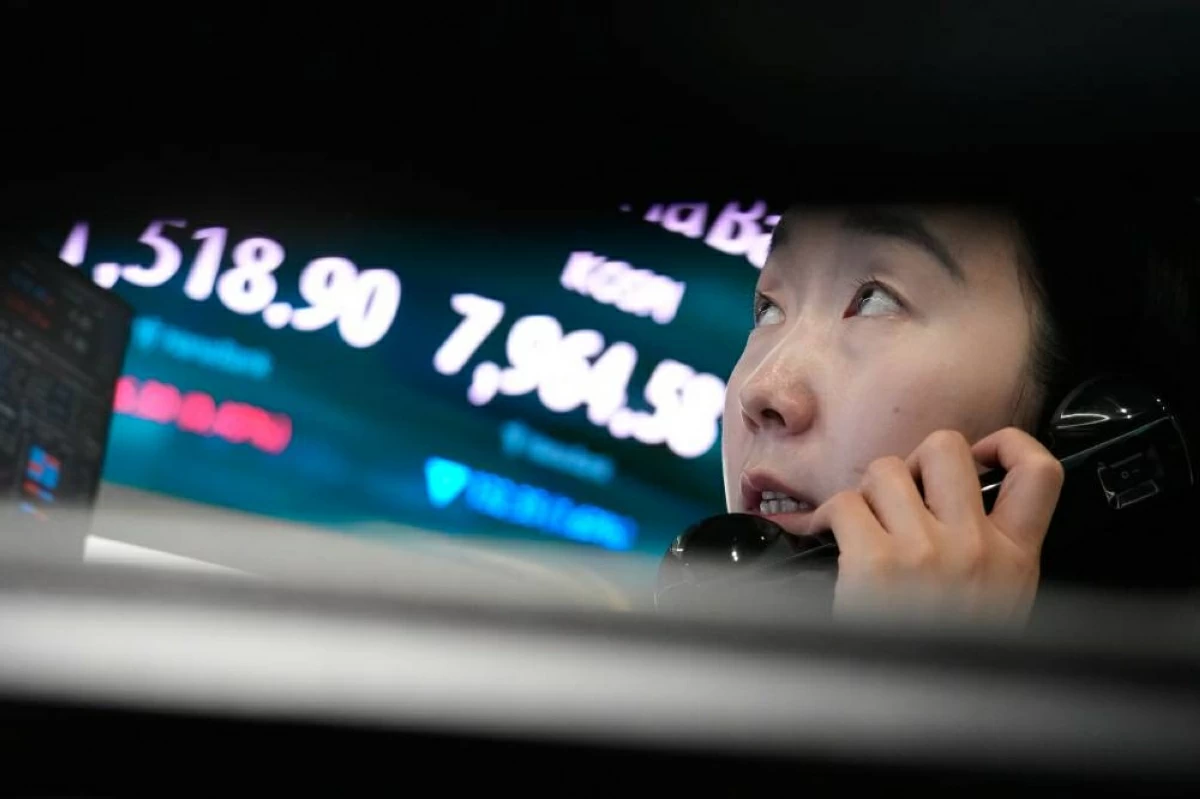 A currency trader talks on the phone near a screen showing the Korea Composite Stock Price Index (KOSPI) and the foreign exchange rate between U.S. dollar and South Korean won at the foreign exchange dealing room of the Hana Bank headquarters in Seoul, South Korea, Wednesday, June 10, 2026. (AP Photo/Ahn Young-joon)