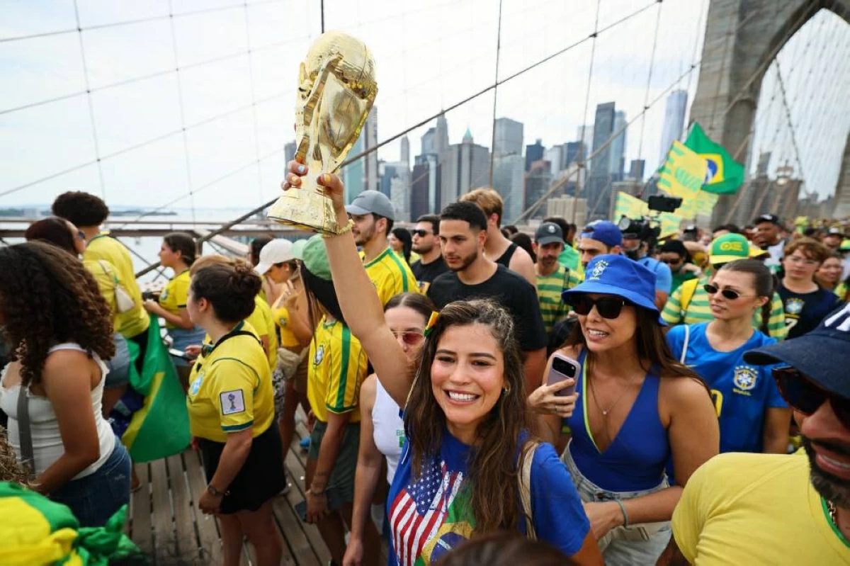 مشجعون برازيليون يحملون نسخة من كأس العالم 