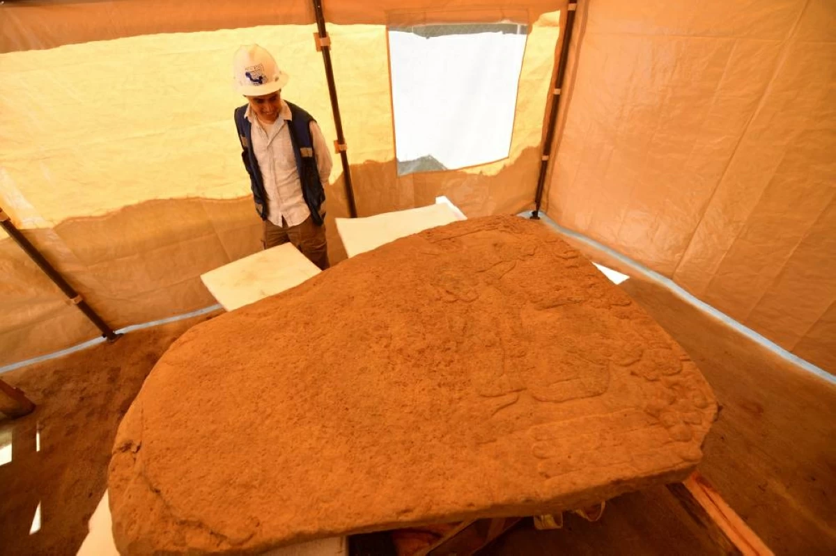 رجل ينظر إلى لوحة حجرية يبلغ ارتفاعها 1,88 متر وعرضها 1,47 متر عثر عليها في ولاية فيراكروز الشرقية (رويترز)
