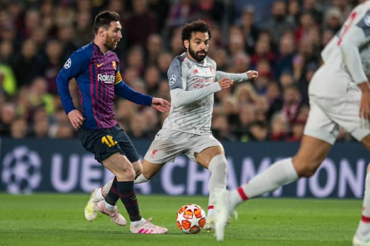 ميسي ومحمد صلاح خلال لقاء سابق بين برشلونة وليفربول