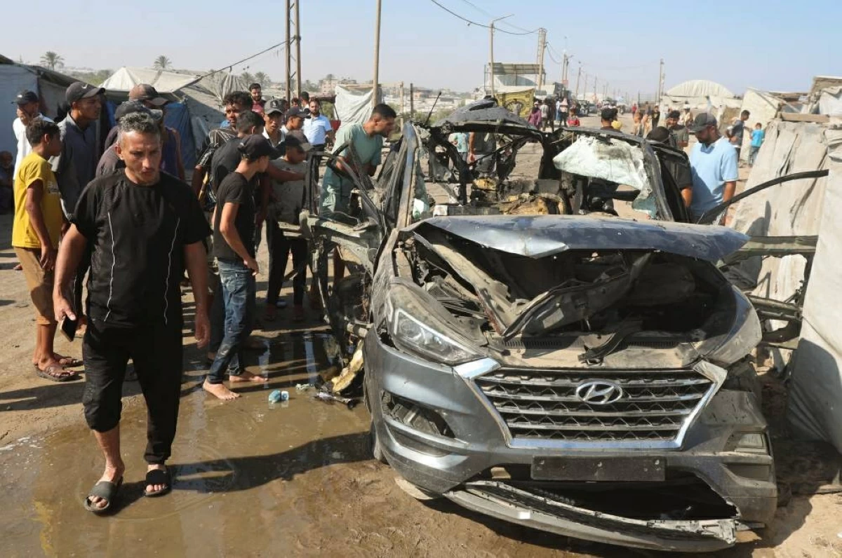 (رويترز) فلسطينيون يتفقدون مركبة استهدفتها غارة إسرائيلية في خان يونس
