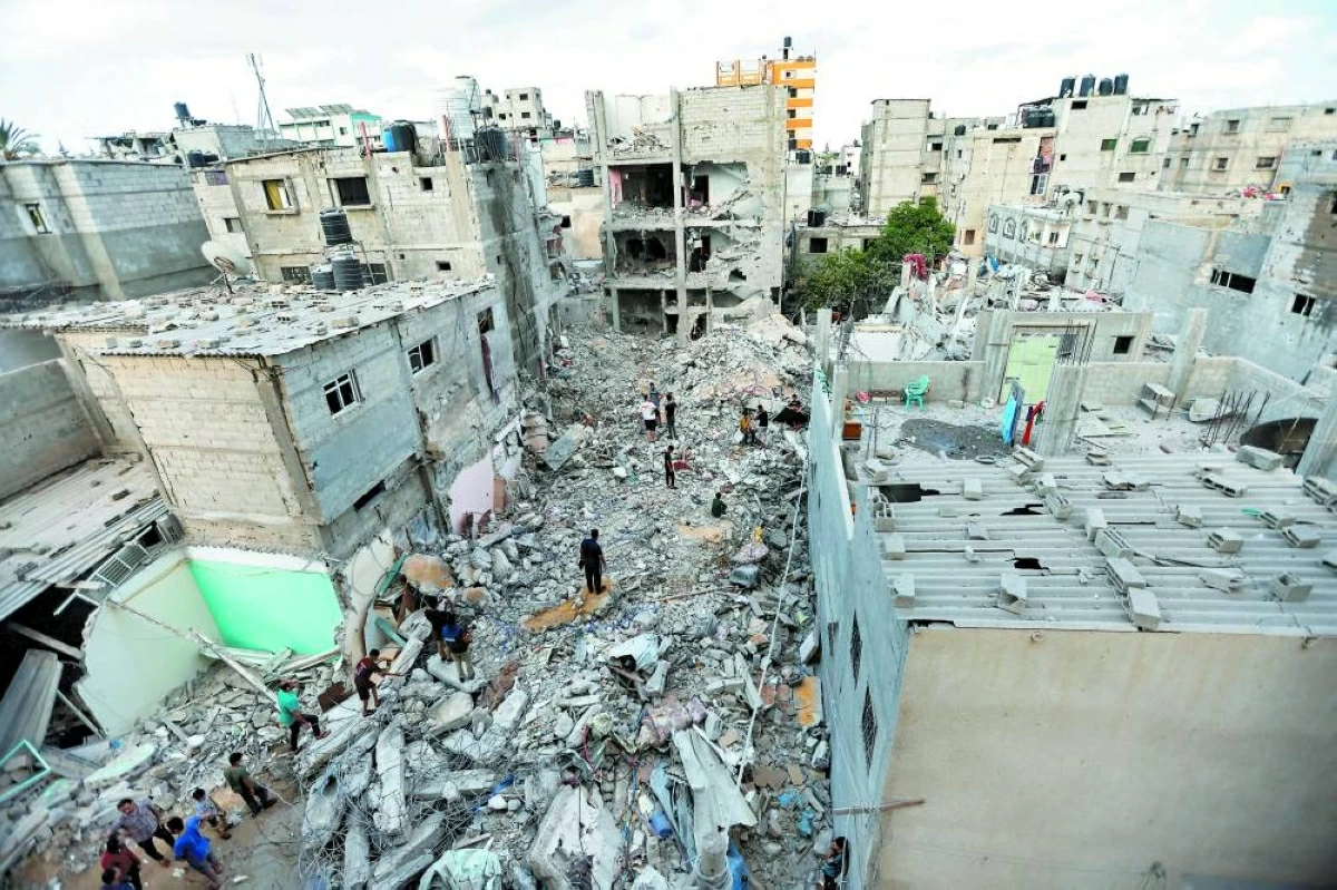 فلسطينيون يتجمعون حول منزل دمرته غارة اسرائيلية على رفح (أرشيفية)