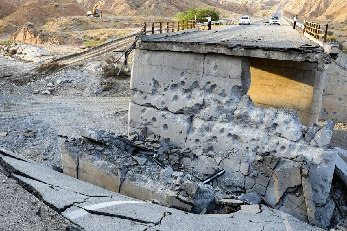 جسر إيراني متضرر بشدة جراء غارة أمريكية على الطريق الذي يربط بين رودان وبندر عباس في جنوب إيران( أ ف ب) 