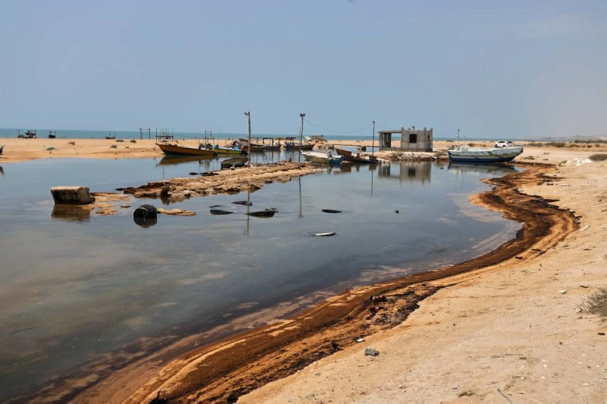 بقايا النفط تغطي أجزاء من الشاطئ بالقرب من قوارب الصيد في جزيرة قشم بإيران(أ ب )
