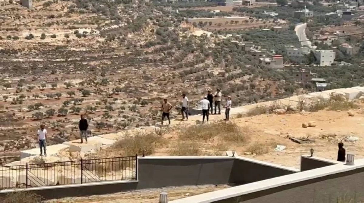 (رويترز) مستوطنون يتجمعون أمام منزل فلسطيني محاصر في قصرة