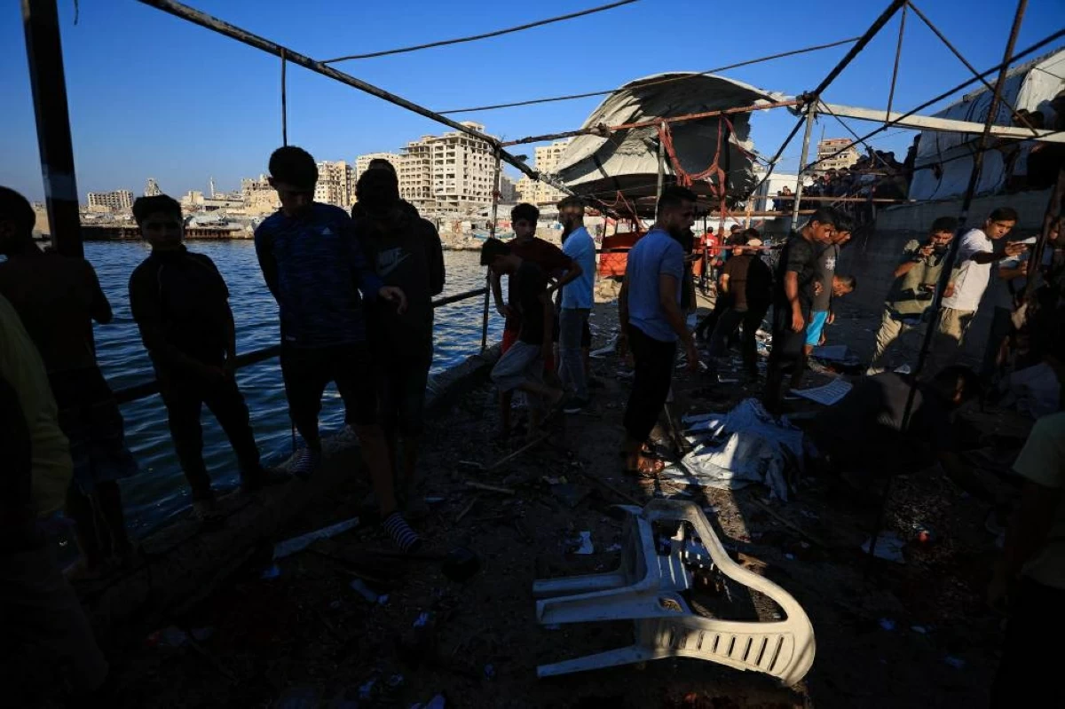 (رويترز) فلسطينيون يتفقدون موقع غارة إسرائيلية استهدفت مقهى في ميناء غزة