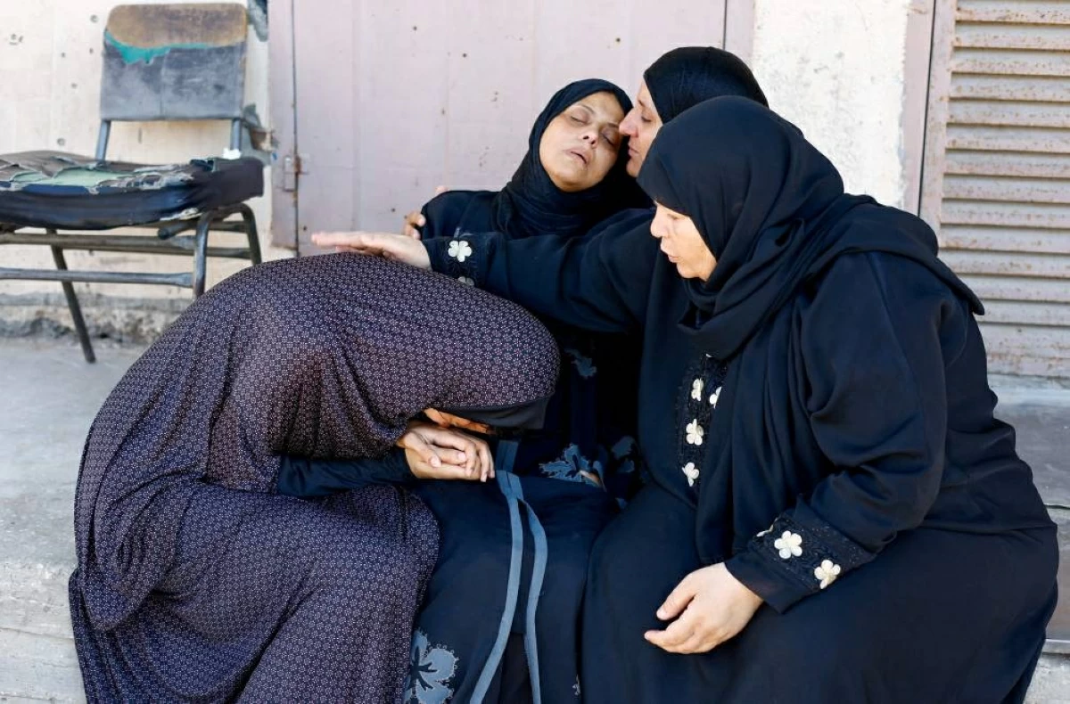 والدة الطفل تيّم حمدان الذي قُتل في غارة إسرائيلية تبكي أثناء جنازته في وسط قطاع غزة (رويترز)
