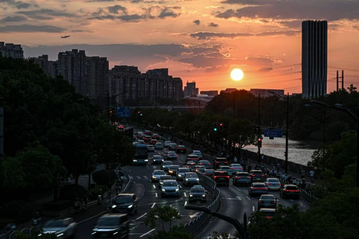 Motorists commute during sunset in Shanghai on September 8, 2026. (Photo by JADE GAO / AFP)