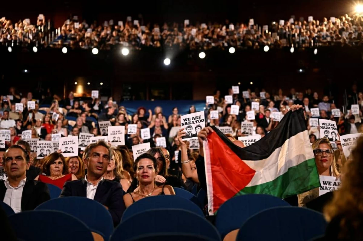 حضور حفل الختام يرفعون علم فلسطين ولافتات تدعم الفيلم الوثائقي «نازا» (أ.ف.ب)