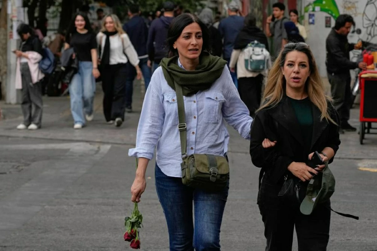 نساء يعبرن تقاطعاً في شارع بوسط طهران (أ ب)