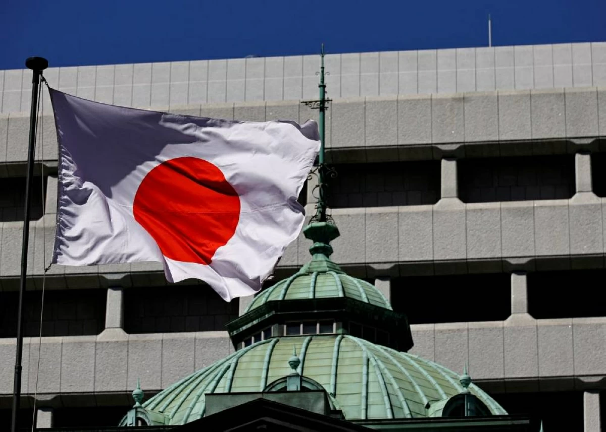FILE PHOTO: The Japanese national flag waves at the Bank of Japan building in Tokyo, Japan March 18, 2024. REUTERS/Kim Kyung-Hoon/File Photo