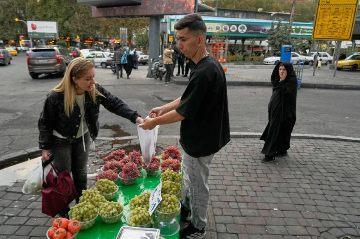 إمراة إيرانية تشتري العنب من بائع متجول في طهران( أ ب )