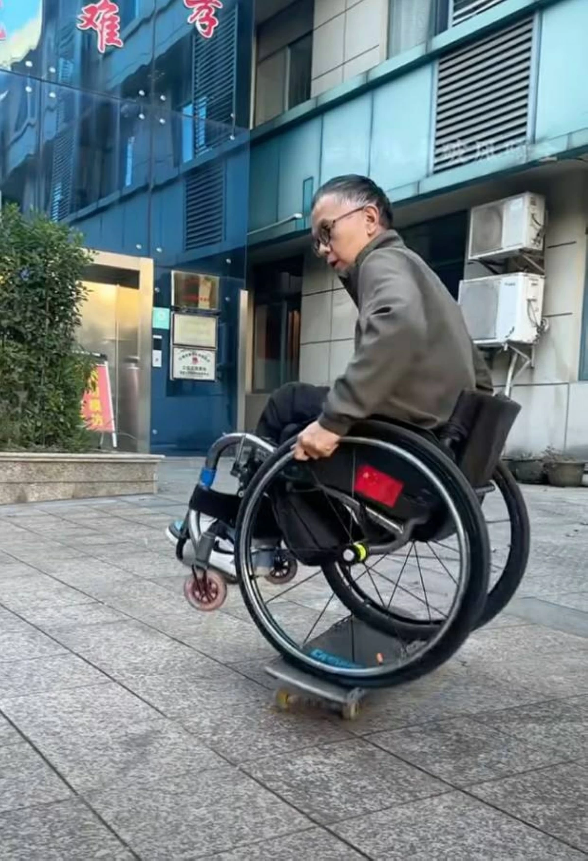 صيني يتزلج على لوح بكرسي متحرك