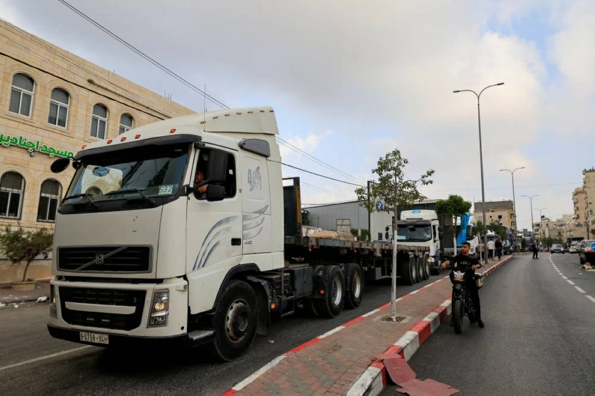  شاحنات فلسطينية متظوعة لنقل منتجات وامدادا المصانع التي ازالتها قوات الاحتلال في الخليل(رويترز)