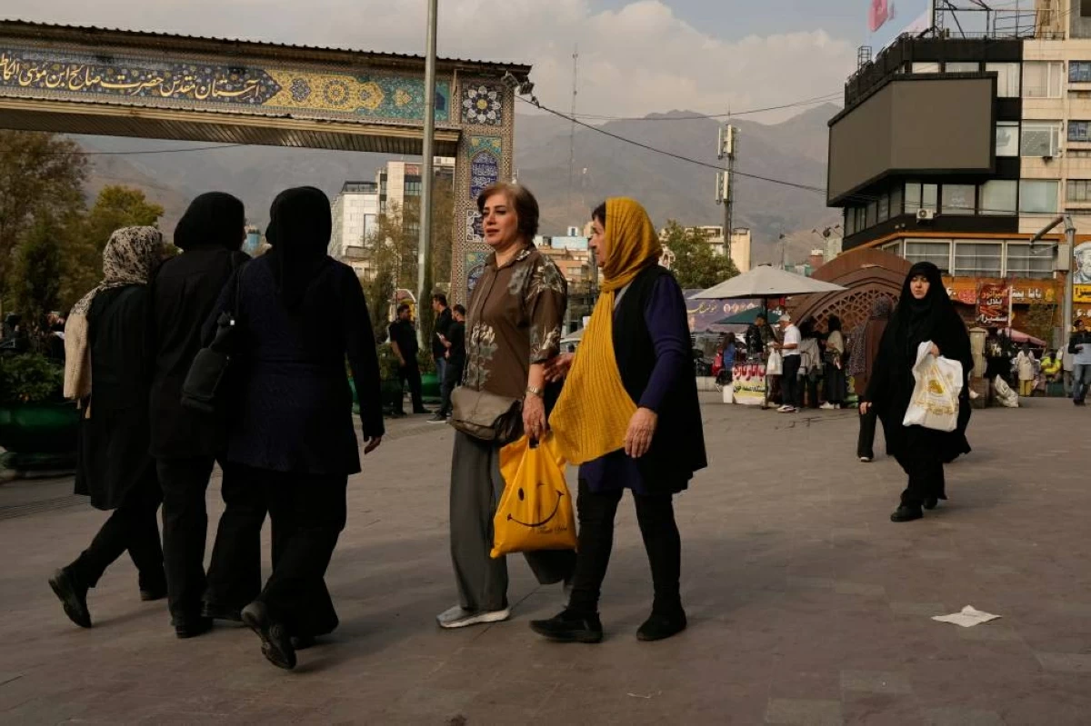 إيرانيات يمشين على رصيف في ساحة تجريش في طهران ( أ ب ) 
