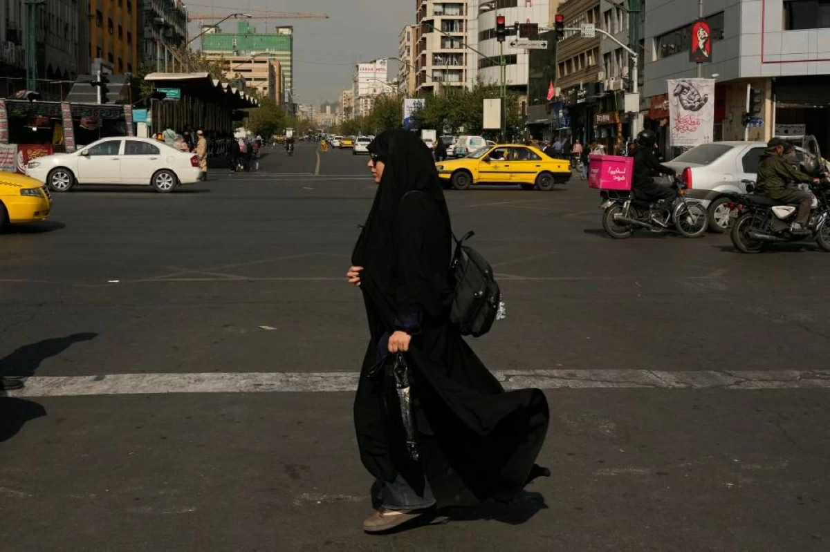 امرأة تعبر تقاطعاً في شارع الثورة الإسلامية في طهران(أ ب )
