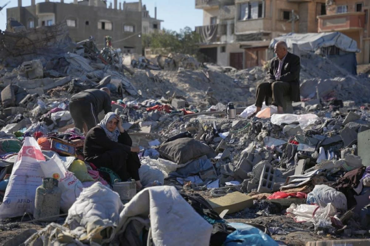 زوجان فلسطينيان وسط ركام منزلهما المدمر في مخيم بريج وسط قطاع غزة(أ.ب)