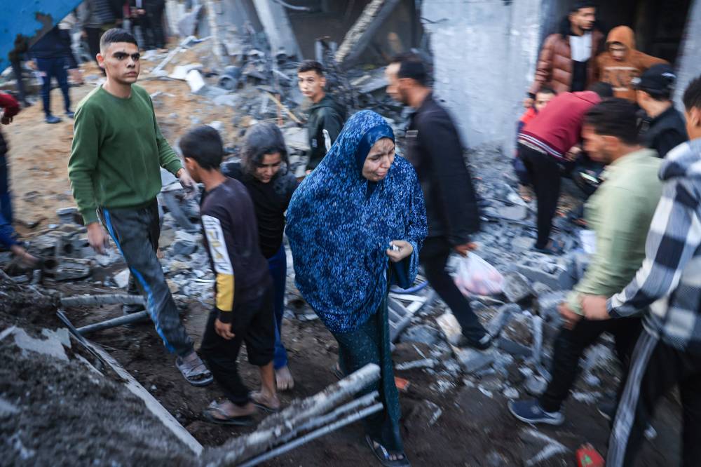 فلسطينيون يتفقدون الأضرار بعد غارة إسرائيلية على رفح (ا ف ب)