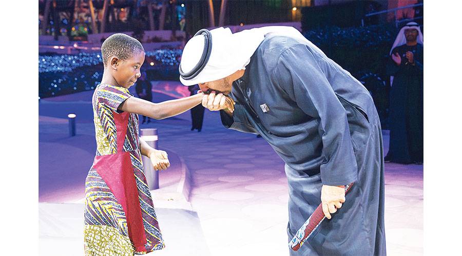 محمد بن زايد مقبلاً بحنان الأب يد الطفلة ماري زايد
