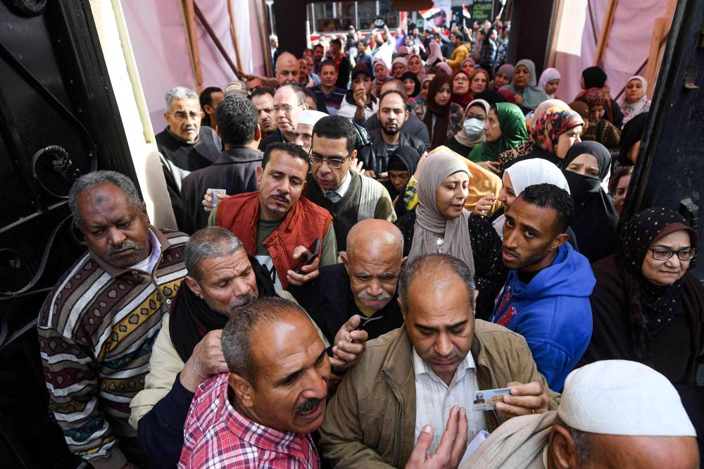 ناخبون مصريون يصطفون أمام إحدى لجان الاقتراع بالقاهرة (أ ف ب )