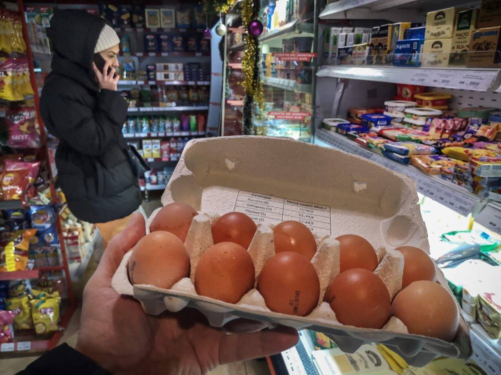 أحد العملاء يحمل علبة من البيض في متجر في موسكو