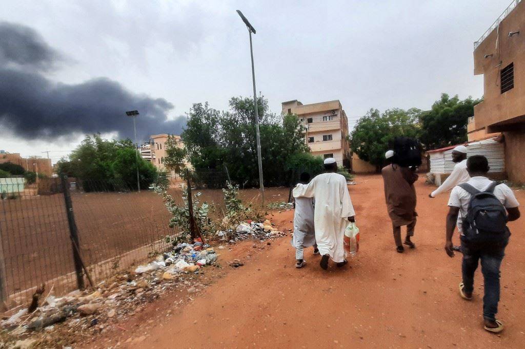 صورة أرشيفية لدخان يتصاعد فوق المباني في الخرطوم بينما يفر السكان من متعلقاتهم أ ف ب).