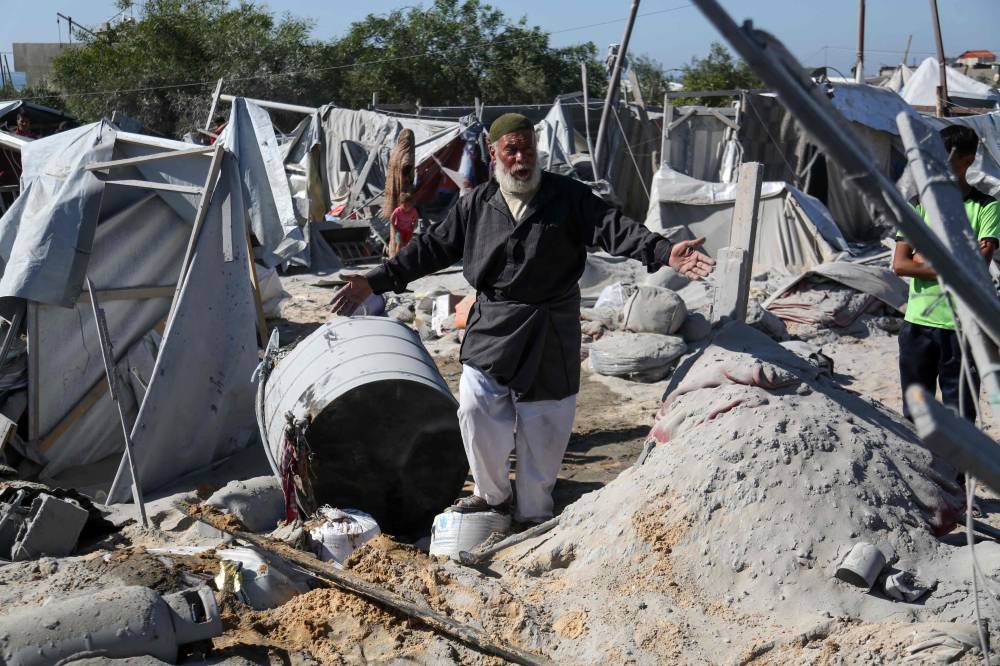 رجل فلسطيني مسن وسط الدمار في مخيم للنازحين (أ ف ب)