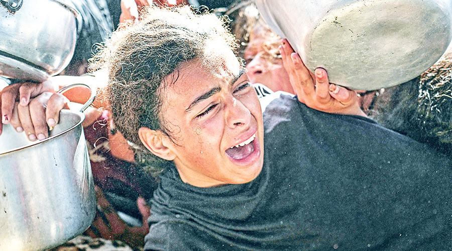 فتاة فلسطينية تحاول الحصول على الطعام في مطبخ مجتمعي بخان يونس (اب) فتاة فلسطينية تحاول الحصول على الطعام في مطبخ مجتمعي بخان يونس (اب)