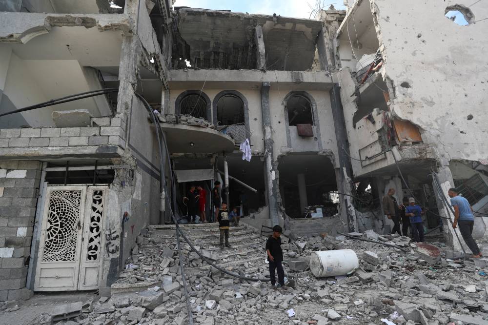 (رويترز) فلسطينيون يتفقدون موقع غارة جوية إسرائيلية على عيادة طبية في جباليا