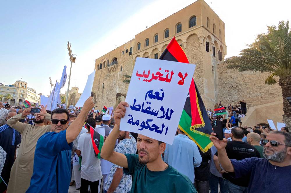 متظاهرون في ميدان الشهداء في طرابلس يطالبون برحيل حكومة الدبيبة (أ ف ب )
