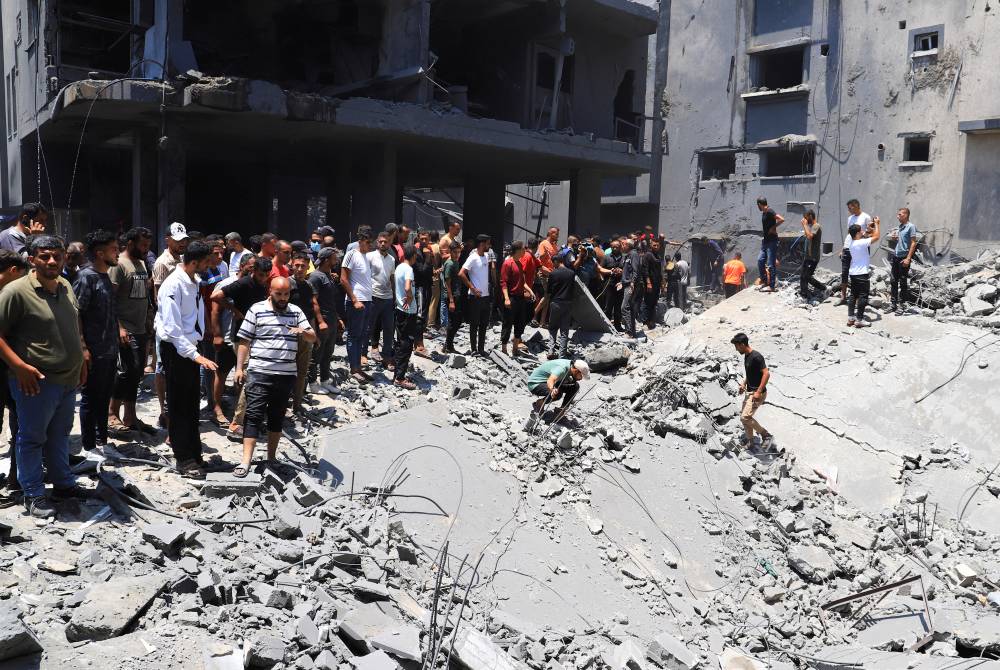 فلسطينيون يبحثون عن ضحايا في موقع غارة إسرائيلية على منزل في مدينة غزة (رويترز)