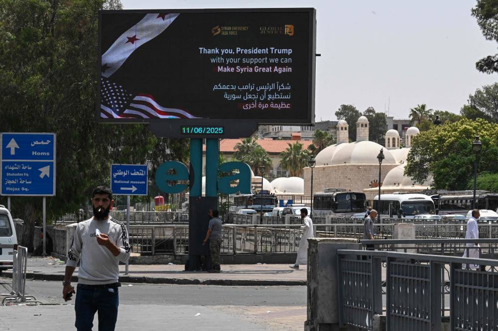 لوحة إعلانية تشكر الرئيس الأمريكي دونالد ترامب على طريق رئيسي في دمشق (أ ف ب)