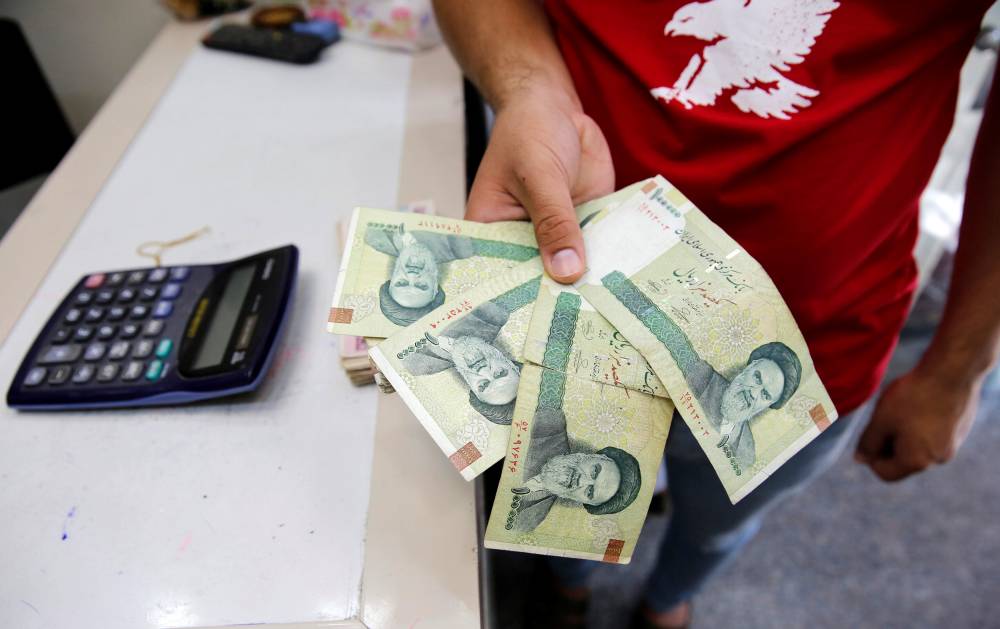 صراف يتفقد الريالات الإيرانية في بغداد (رويترز - أرشيفية) صراف يتفقد الريالات الإيرانية في بغداد (رويترز - أرشيفية)