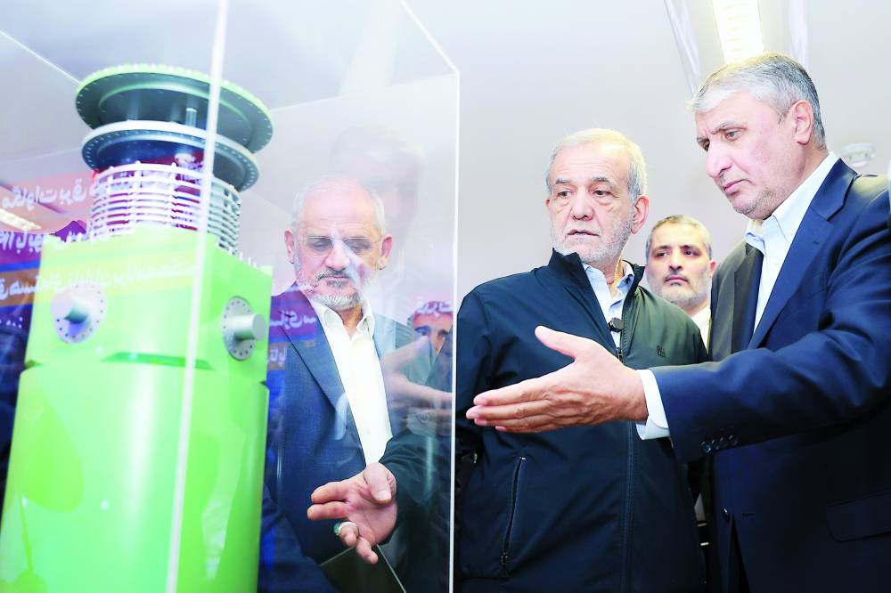 بزشكيان يستمع إلى رئيس منظمة الطاقة الذرية الإيرانية أثناء زيارته لمعرض للإنجازات النووية بطهران (ارشيفية)