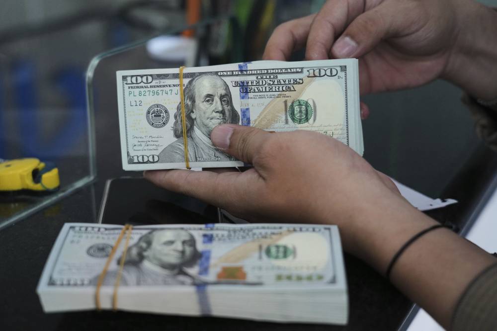 موظف يحسب أوراق الدولار الأمريكي في محل صرافة بجاكرتا. إندونيسيا ( أ ب)