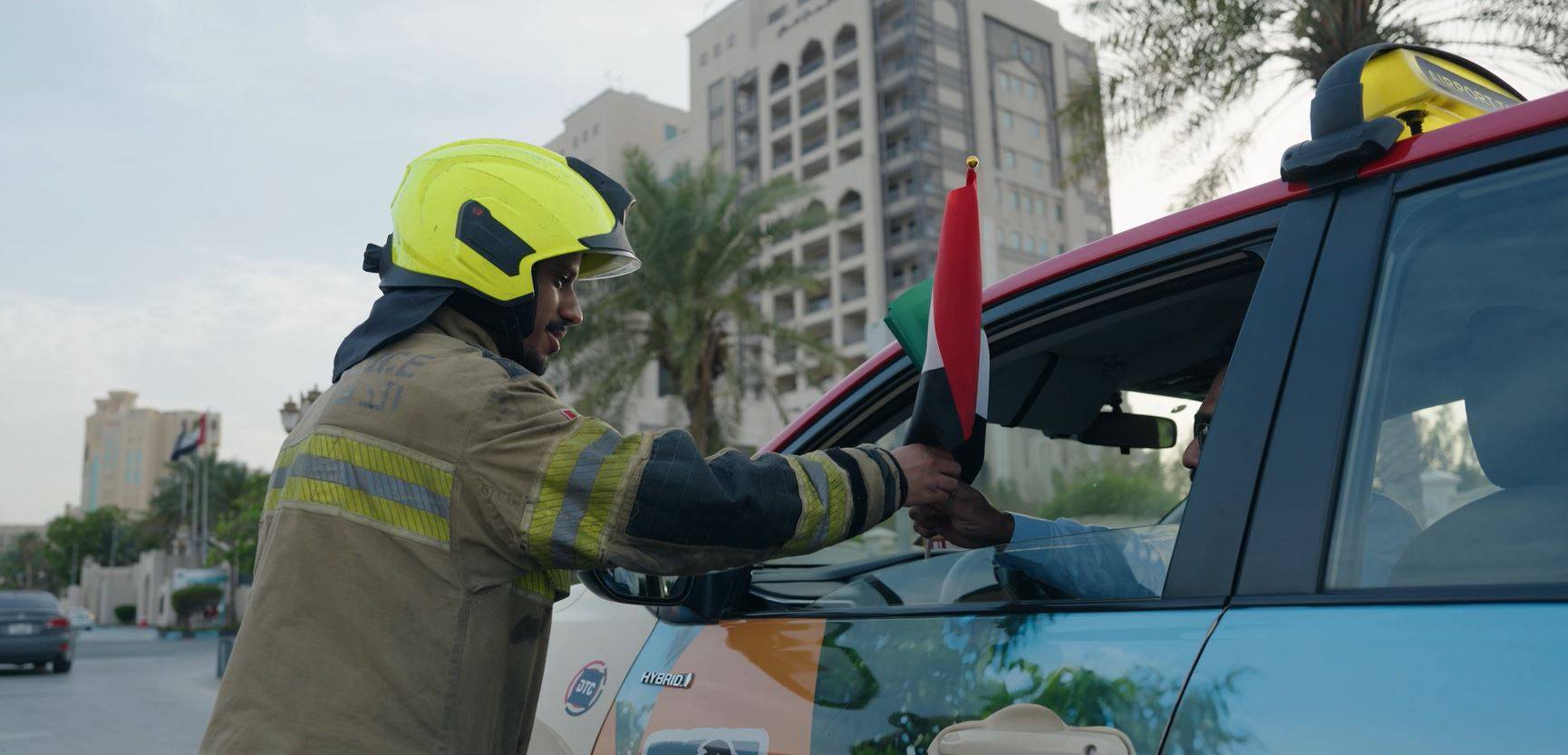 الدفاع المدني والإسعاف الوطني وشرطة عجمان توزع أعلام الإمارات على المواطنين والمقيمين 