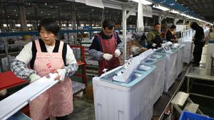 عمال في مصنع لإنتاج الغسالات في مدينة سوتشيان بمقاطعة جيانغسو شرقي الصين (أ.ب)