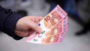 رجل يعرض أوراقًا نقدية من فئة اليورو بعد سحبها من جهاز صراف آلي في صوفيا، بلغاريا (رويترز)