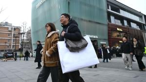 مارة أمام مركز تجاري في بكين (أ.ف.ب)