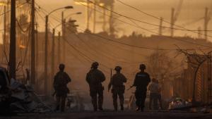 جنود تشيليون يتفقدون المناطق المتضررة بعد حريق هائل في مدينة كونسبسيون. (أ.ف.ب)