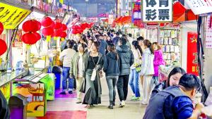 مارة في شارع مليء بأكشاك الطعام في سوق تايدونغ الليلي بمدينة تشينغداو الصينية (أرشيفية)