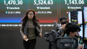 وسطاء عملات أمام شاشة تعرض مؤشر كوسبي للأسهم الكورية الجنوبية في مقر بنك هانا في سيول (أ.ب)