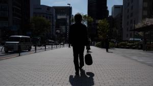 رجل يحمل حقيبة وهو متوجه إلى عمله في أحد شوارع طوكيو