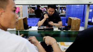 موظفون في خط تجميع حوامل الهواتف الذكية للسيارات في مصنع لملحقات البلاستيك، في دونغقوان، بمقاطعة قوانغدونغ، الصين (رويترز)